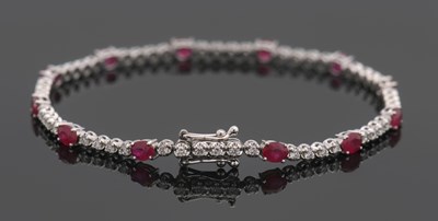 Lot 337 - An 18ct ruby and diamond bracelet, set with...