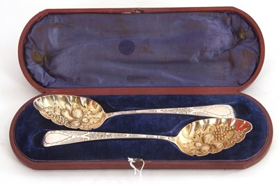 Lot 103 - A cased pair of George III silver berry spoons...