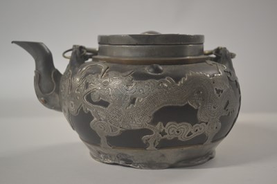 Lot 214 - A Chinese pewter teapot decorated with dragons...