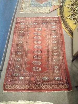 Lot 456 - A 20th Century Afghan red ground rug decorated...