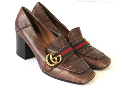 Lot 77 - Gucci: a pair of borwn leather heeled loafers,...