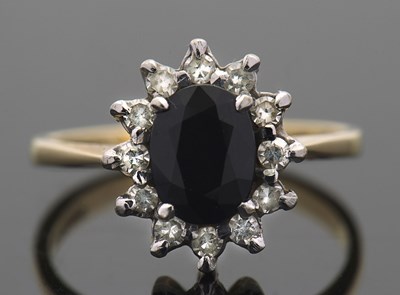 Lot 428 - An 18ct sapphire and diamond cluster ring, the...