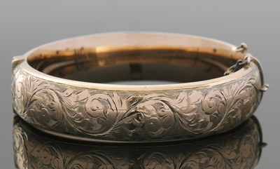 Lot 435 - A 9ct bangle, the hinged bangle with engraved...
