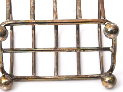Lot 87 - An Edwardian silver toast rack featuring four...