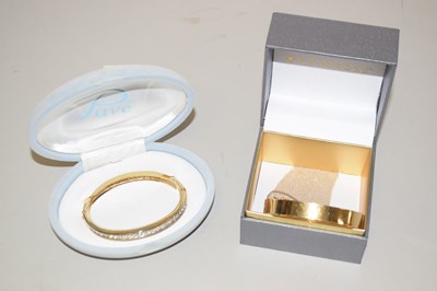 Lot 126 - A rolled gold bangle and a further gold plated...