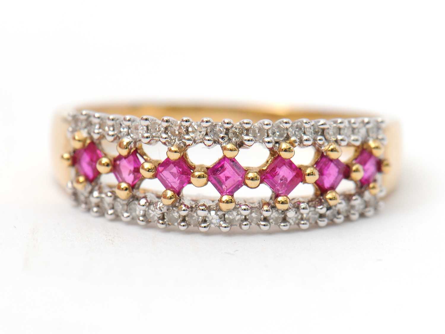 Lot 33 - A 9ct ruby and diamond ring, with central row...