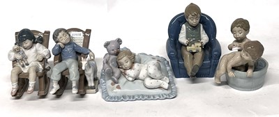 Lot 344 - Group of Lladro models of children seated in...