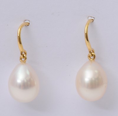 Lot 66 - A pair of cultured pearl earrings, the oval...