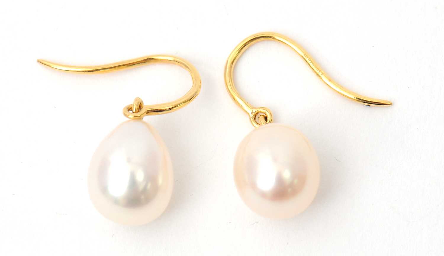 Lot 66 - A pair of cultured pearl earrings, the oval...