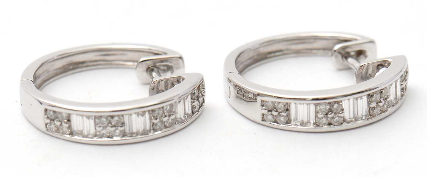 Lot 59 - A pair of 18ct diamond earrings, the hinged...