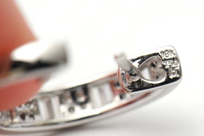 Lot 59 - A pair of 18ct diamond earrings, the hinged...