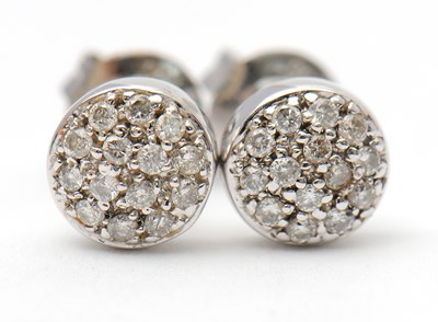 Lot 42 - A pair of diamond earrings, the slightly domed...