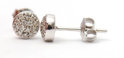 Lot 42 - A pair of diamond earrings, the slightly domed...