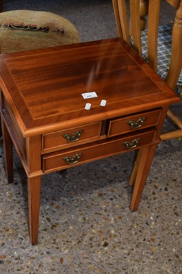 Lot 443 - A small reproduction three drawer lamp table