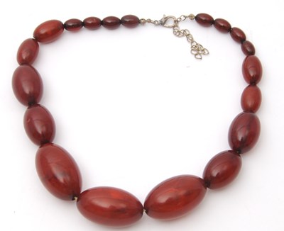 Lot 135 - A bakelite faux 'cherry' amber bead necklace,...