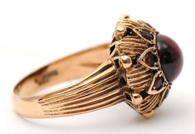 Lot 22 - A garnet dress ring, with central round garnet...