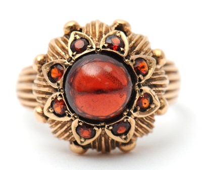 Lot 22 - A garnet dress ring, with central round garnet...