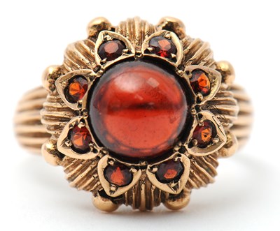 Lot 22 - A garnet dress ring, with central round garnet...