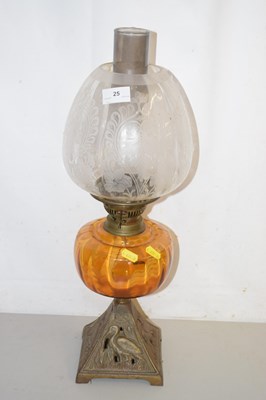 Lot 25 - An oil lamp with amber glass font