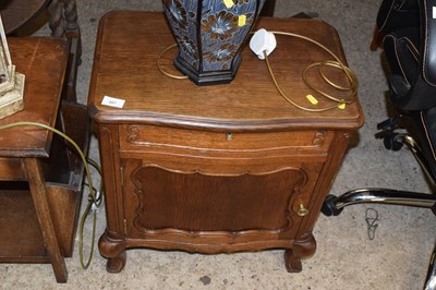 Lot 307 - A continental oak bedside cabinet