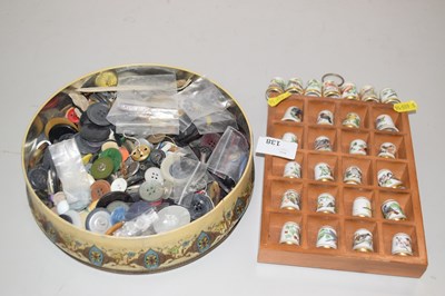 Lot 138 - A tin of buttons together with a display case...