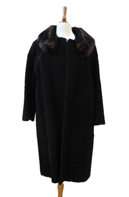 Lot 158 - A black astrkhan and fur trimmed coat by...