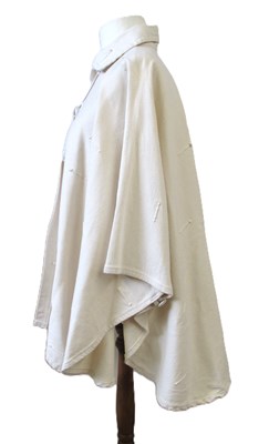 Lot 80 - A cream cotton cape by Lydia G, with button...
