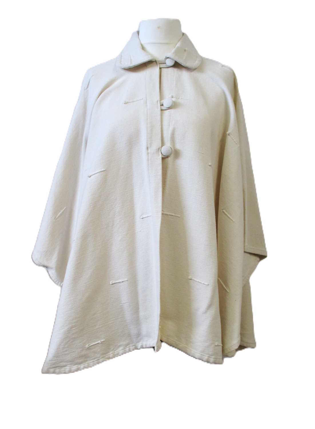 Lot 80 - A cream cotton cape by Lydia G, with button...
