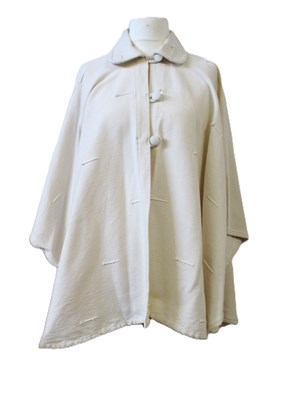 Lot 80 - A cream cotton cape by Lydia G, with button...