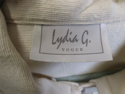 Lot 80 - A cream cotton cape by Lydia G, with button...