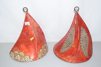 Lot 530 - A pair of leather wall decorations