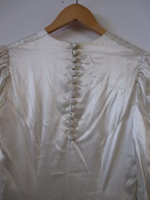 Lot 24 - A mid 20th century wedding dress, the cream...