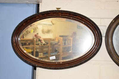 Lot 650 - An oval bevelled wall mirror