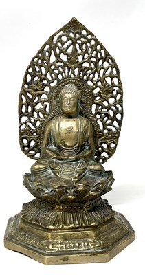 Lot 216 - A bronze model of Buddha seated with a pierced...