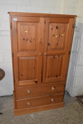 Lot 224 - A small pine wardrobe with two drawer base