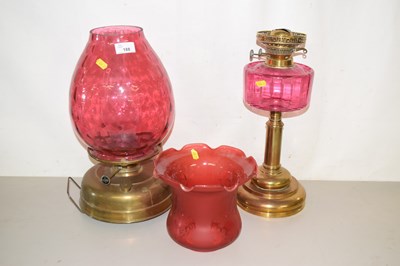 Lot 188 - An oil lamp with red glass frilled shade and a...