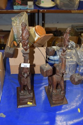 Lot 609 - Two carved wooden elephants with balanced...