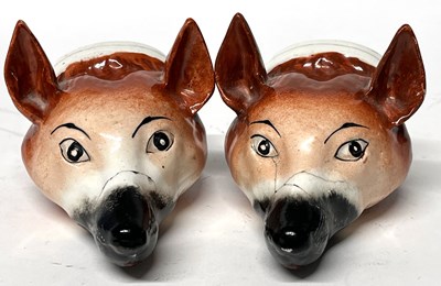 Lot 310 - Pair of porcelain stirrup cups modelled as fox...