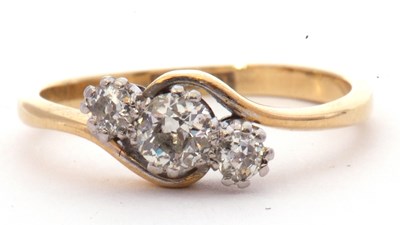 Lot 12 - Three stone diamond cross over ring featuring...