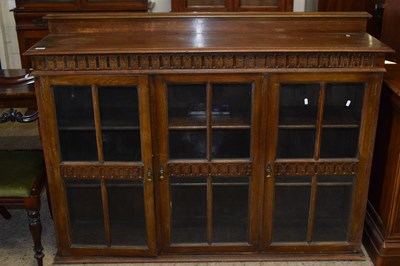 Lot 244 - An early 20th Century oak three door bookcase...