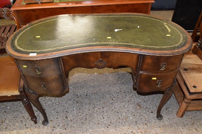 Lot 257 - A 20th Century kidney shaped desk with green...