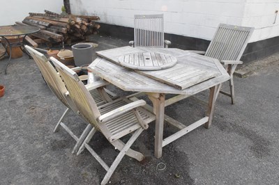 Lot 355 - An octagonal weathered teak garden table and...
