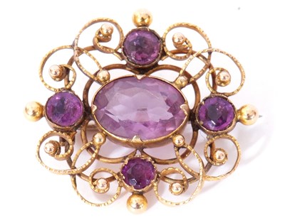 Lot 254 - Yellow metal and amethyst brooch, the ornate...
