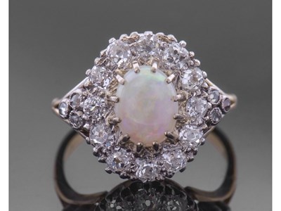 Lot 187 - Opal and diamond cluster ring centring an oval...