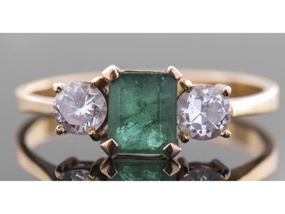 Lot 190 - Emerald and diamond three stone ring centring...