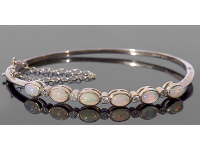Lot 260 - 9ct gold opal and diamond set hinged bracelet,...