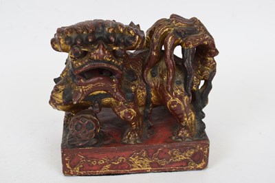 Lot 13 - Oriental stone lion with red and gilt painted...