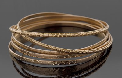 Lot 395 - Five yellow metal bangles, all unmarked, test...