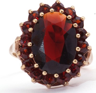 Lot 42 - Garnet cluster dress ring, the large oval...