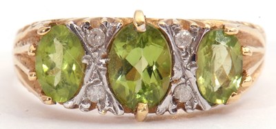 Lot 76 - Modern peridot and diamond ring featuring...